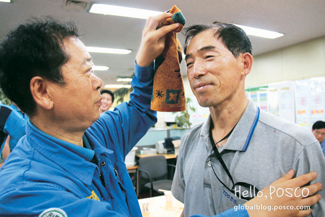 A Pohang Steelworks employee is wiping the face of his fellow employee from TCC Hanjin