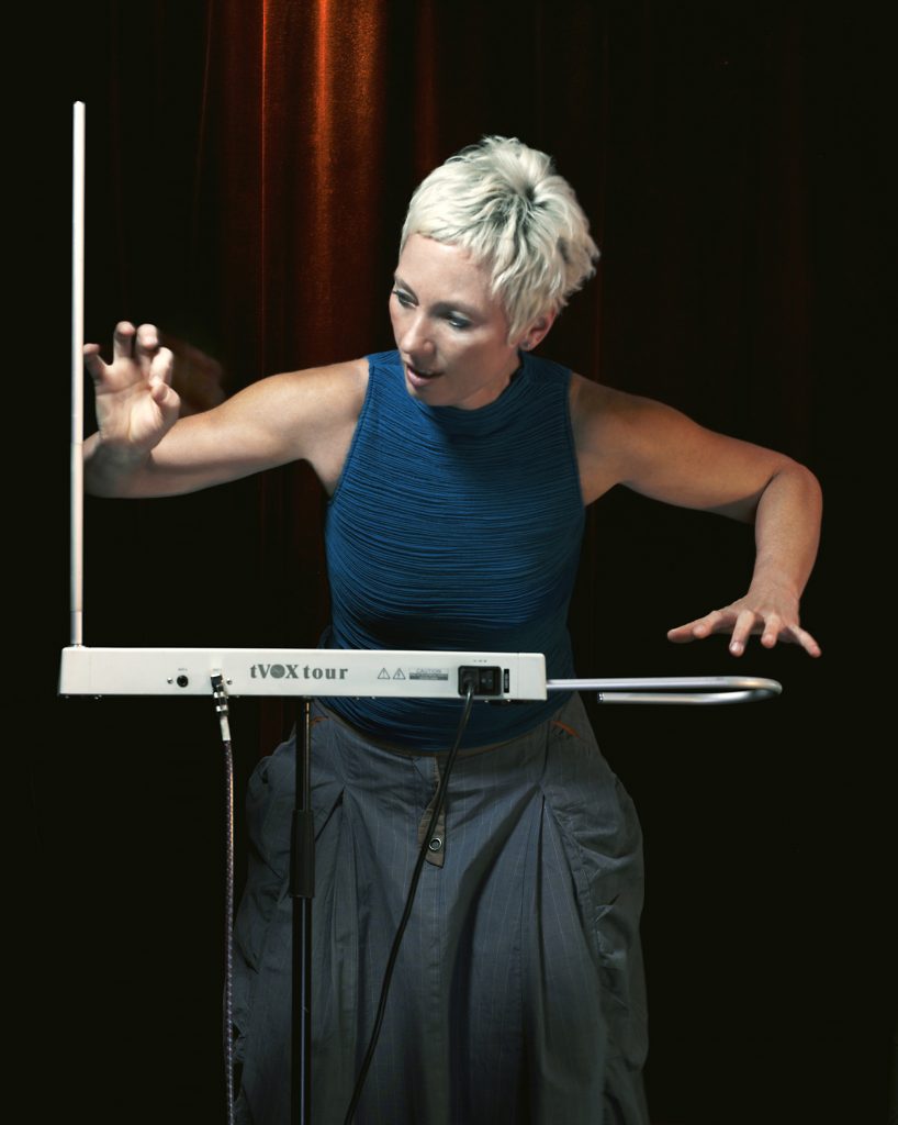 Barbara Buchholz plays the theremin with her hands gliding over the metal antennae