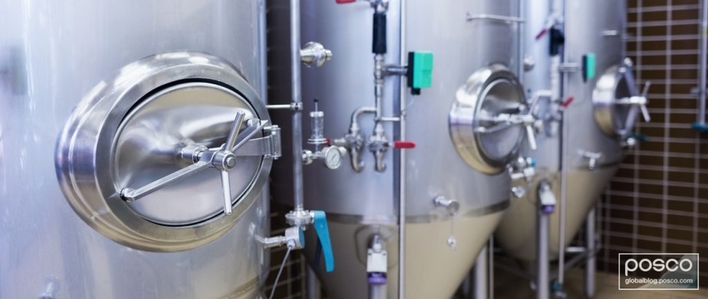 Three large stainless steel vessels for beer in a brewery