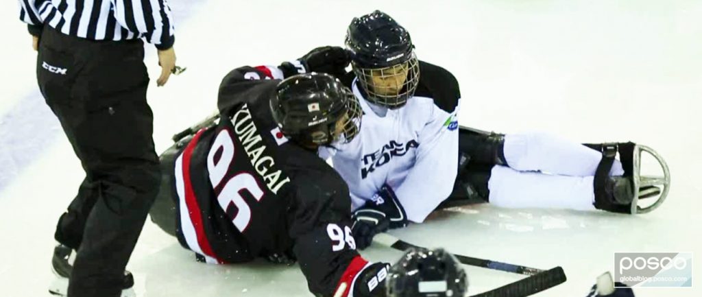 A Korean National Para Ice Hockey Team player fights for the puck during a game against Japan.