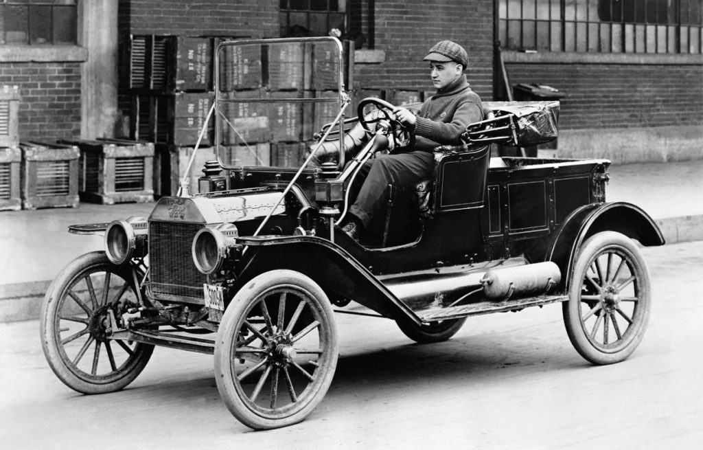 A man drives a Ford Model T in the 1920s.
