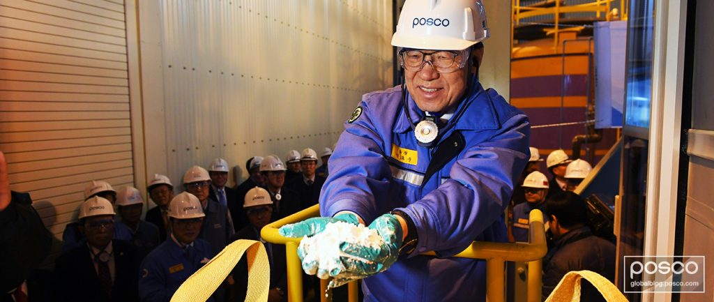 POSCO CEO Kwon Ohjoon holds lithium in both his hands while employees watch on at the PosLX, POSCO’s battery production factory for mining lithium.