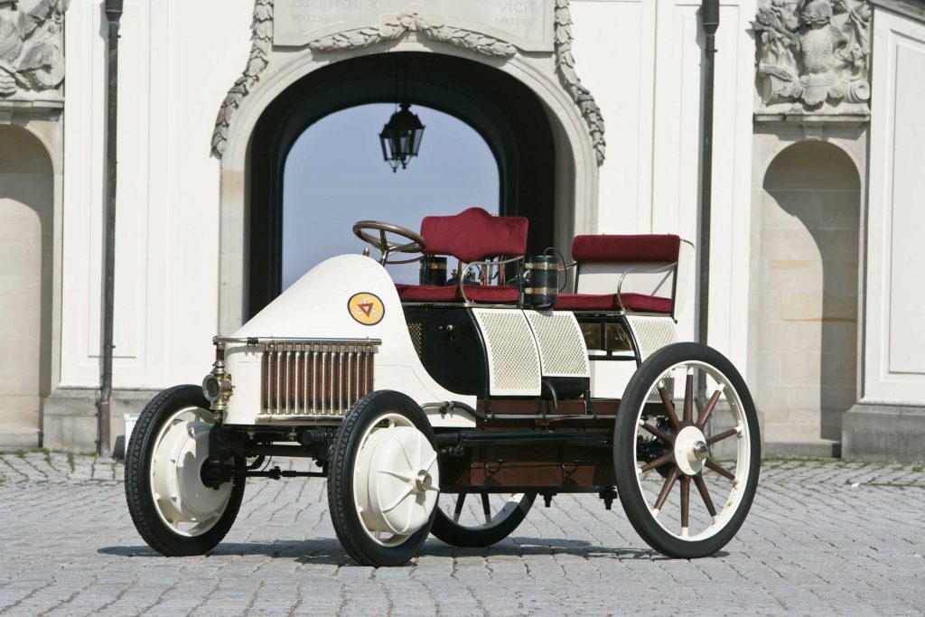 A recreation of the Semper Vivus, the first hybrid EV made by Ferdinand Porsche in white and burgundy.