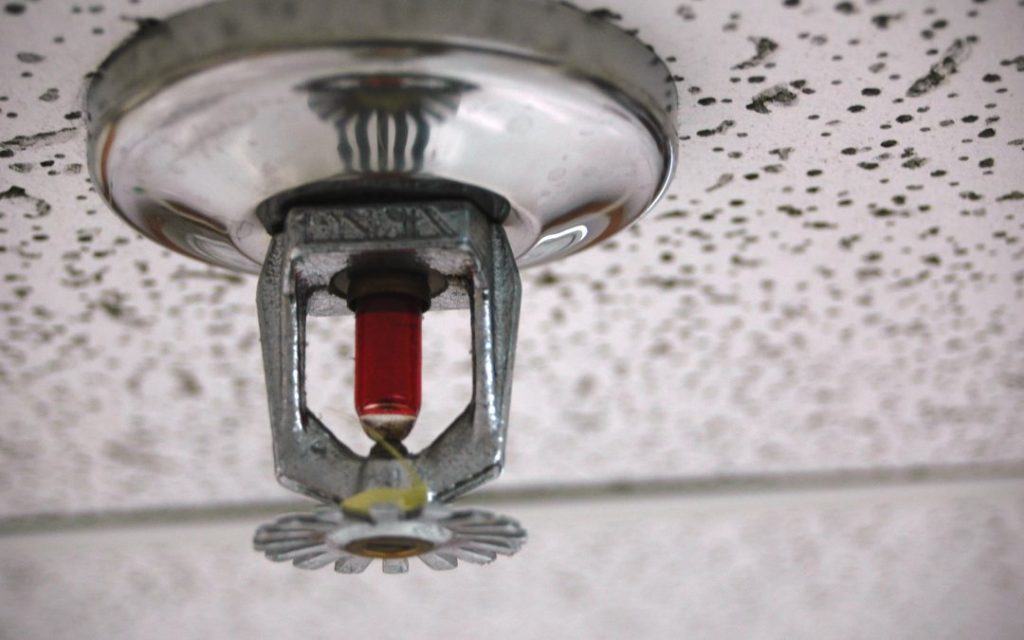 A sprinkler on the ceiling for fire protection.