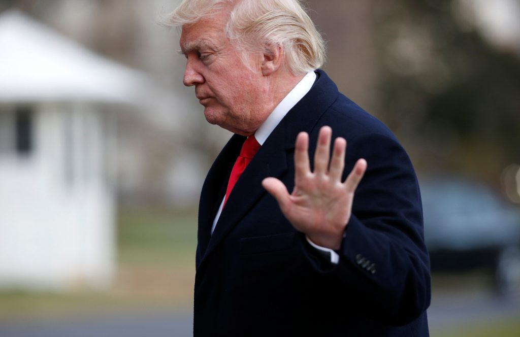U.S. President Donald Trump turns away and waves his hand.