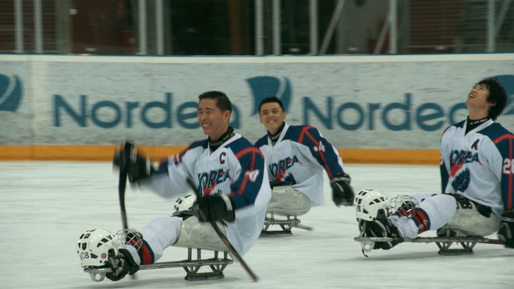 The Korean National Para Ice Hockey Team smiling during a game.
