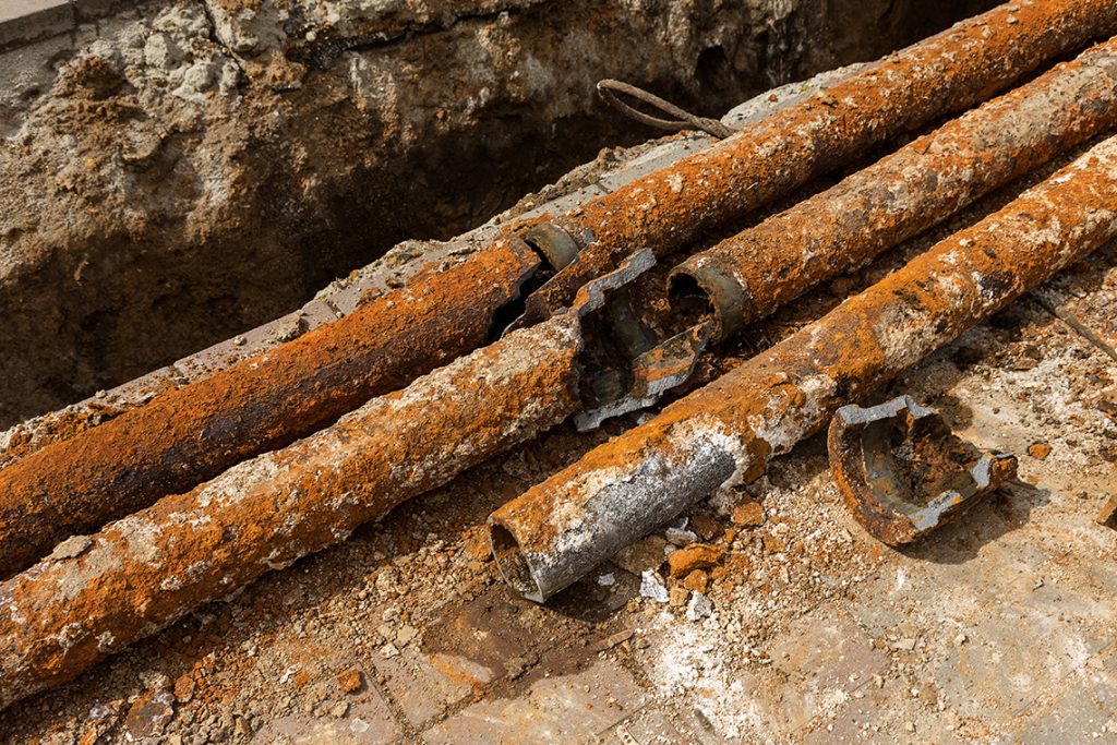 Three broken and rusty water pipes.
