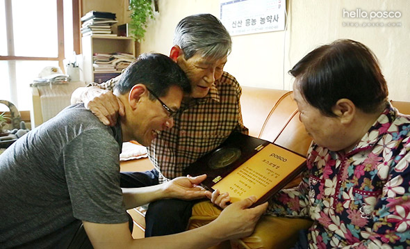 포스코명장이 되고 나서 임명패를 들고 고향에 부모님을 찾아뵙고 있는 모습 