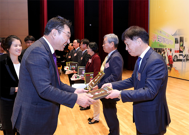 김동원 포스코켐텍 광양사업본부장이 우기종 전라남도정무부지사로부터 '자원봉사 우수기업' 현판을 전달받고 있다.