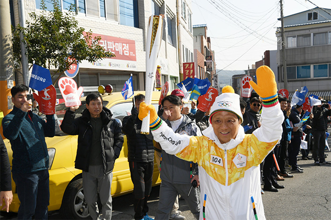 포스코가 11월 18일 2018 평창동계올림픽 광양구간 성화봉송에 함께했다. 광양지역 4번 주자로 김학동 광양제철소장이 시민들의 환호를 받으며 달리고 있다.