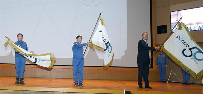 권오준 회장이 2018년 시무식에서 창립 50주년 공식 엠블럼이 새겨진 기(旗)를 흔들어 보이고 있다.