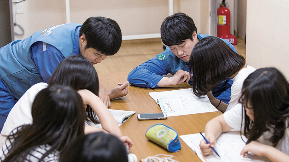 젊은 엔지니어들이 아이들 공부를 가르쳐 주고 있다.