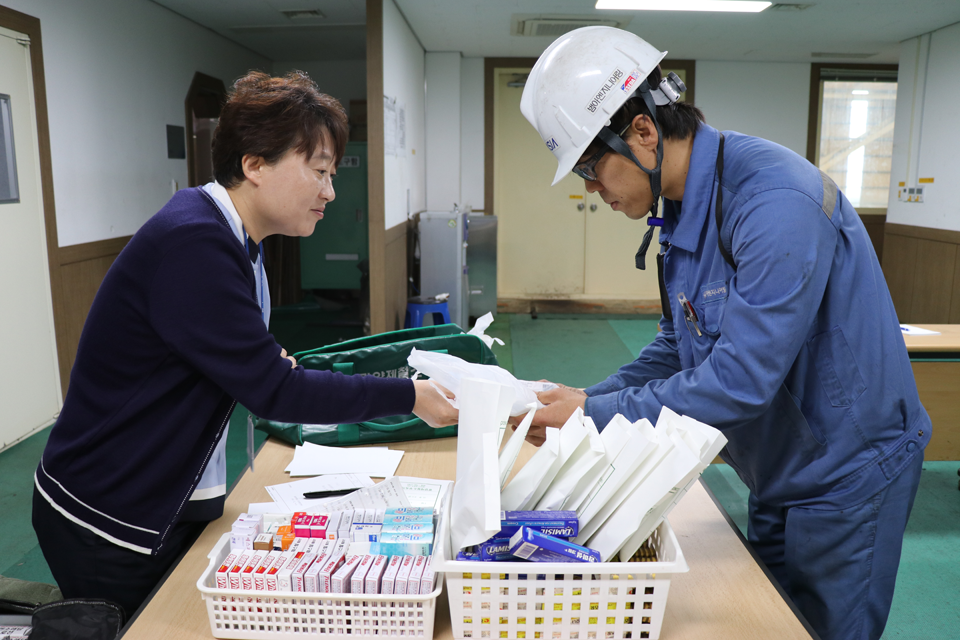 건강증진섹션 진료팀 간호사가 작업자의 질병, 혈압, 건강상태에 맞춘 전문의약품을 나눠주고 있다.