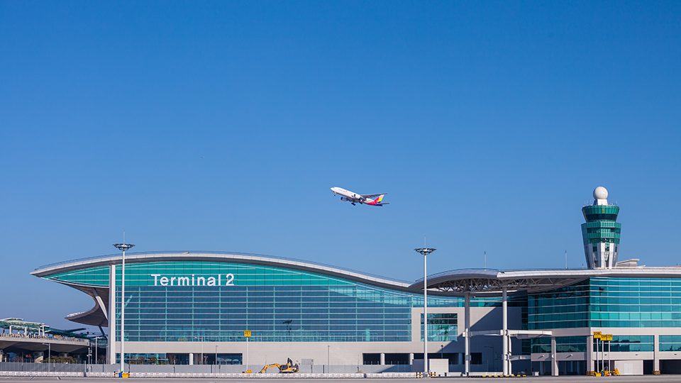 인천공항 제2여객터미널 위로 비행기가 날아가고 있다.