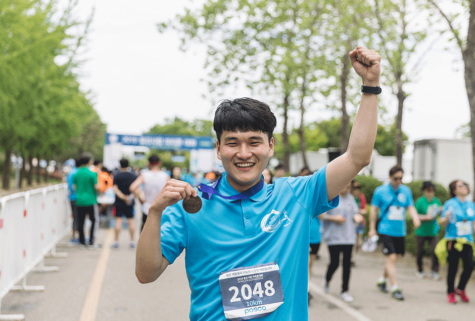 완주 메달을 목에 걸고 환호하는 김진혁 사원