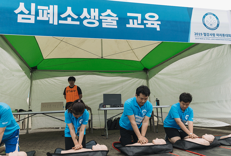 심폐소생술 교육 부스에서 심폐소생술을 직접 체험하는 이정민 차장과 가족들 