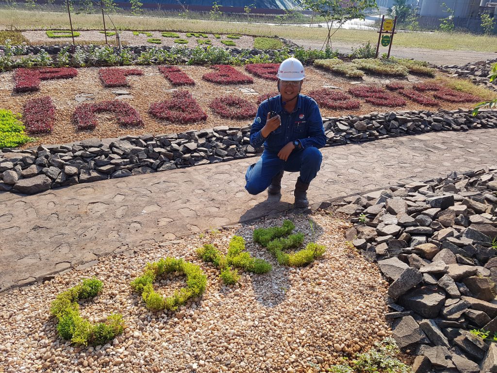 잔디로 Pride of Indonesia가 새겨져있는 화단 앞에서 포즈를 취하고 있는 무클리스 주니어 리더