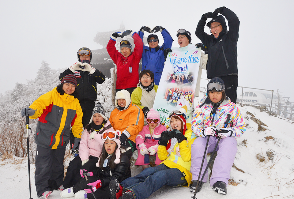 다문화 가정 가족들과 함께 스키장에서 즐거운 시간을 보내고 사진을 찍고있는 이현수 과장