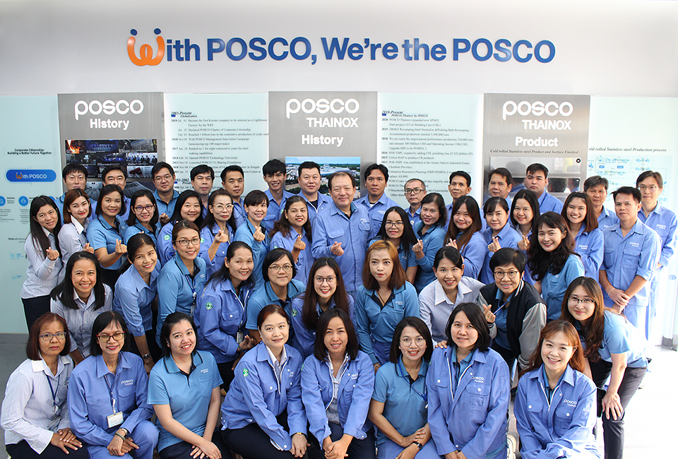 포스코타이녹스 현지직원들이 With POSCO, We’re the POSCO 앞에서 단체로 기념촬영을 하고 있다.