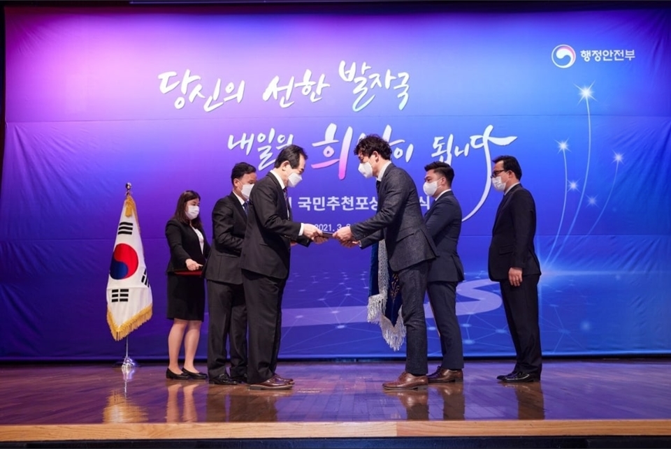 포항 클린오션봉사단장인 이상길 과장(오른쪽에서 세번째)이 정세균 국무총리로부터 대통령 표창을 수상하고 있다. 행정안전부 로고가 인물 뒤의 배경으로 걸려있으며, 당신의 선한 발자국 내일의 희망이 됩니다. 라는 문구가 적혀있다. 