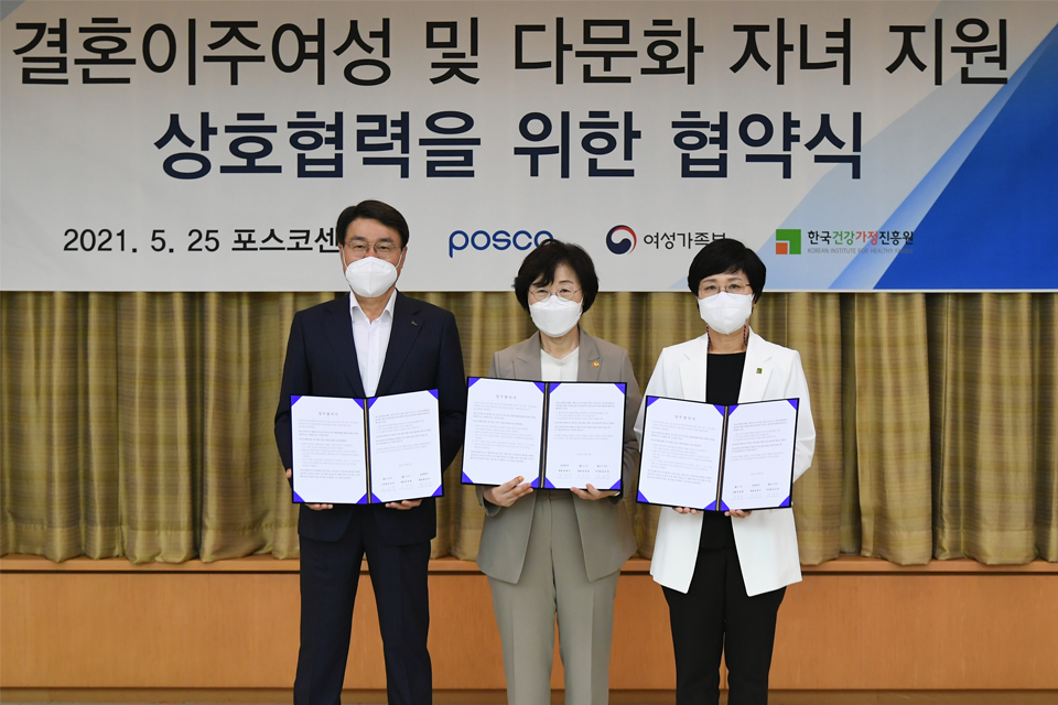 포스코가 25일 서울 포스코센터에서 여성가족부, 한국건강가정진흥원과 결혼이주여성 및 다문화 자녀 지원 상호협력을 위한협약식을 가졌다. 왼쪽부터 최정우 포스코 회장, 정영애 여성가족부 장관, 김금옥 한국건강가정진흥원 이사장. 협약증서를 펼치고 있으며 뒤쪽의 포스터에는 포스코, 여성가족부, 한국건강가정진흥회 로고가 삽입되어있고, 결혼이주여성 및 다문화 자녀 지원 상호협력을 위한 협약식이라는 문구가 크게 적혀있다.