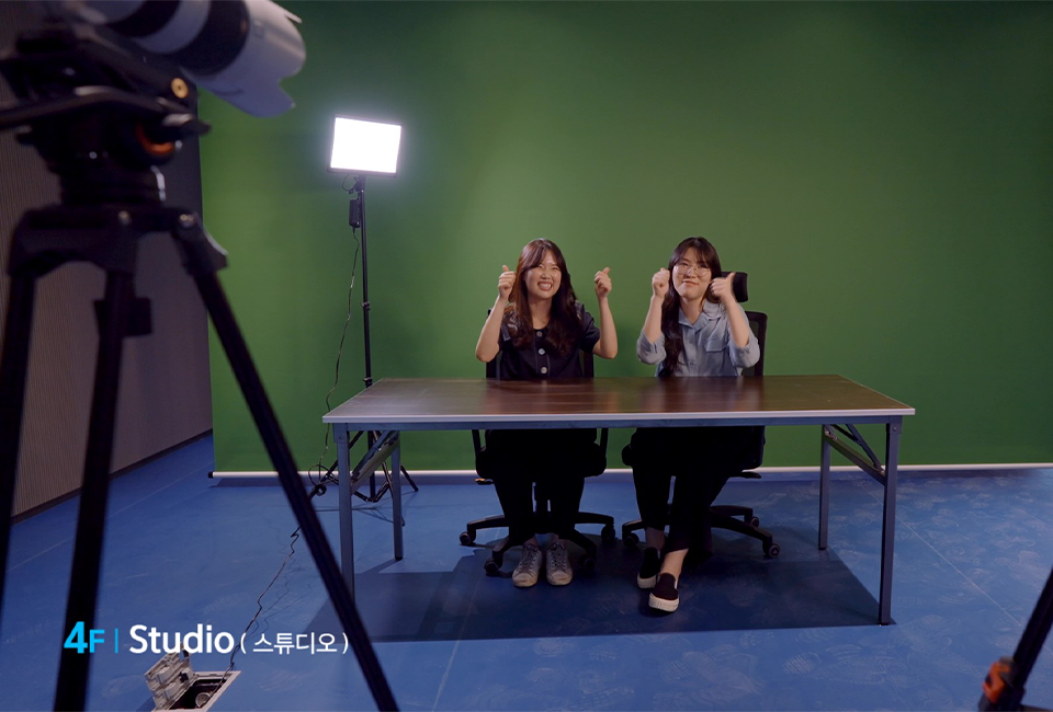 4F Studio (스튜디오) 공간에서 2명의 여자들이 양쪽 엄지를 들고 촬영을 하고 있는 모습. 