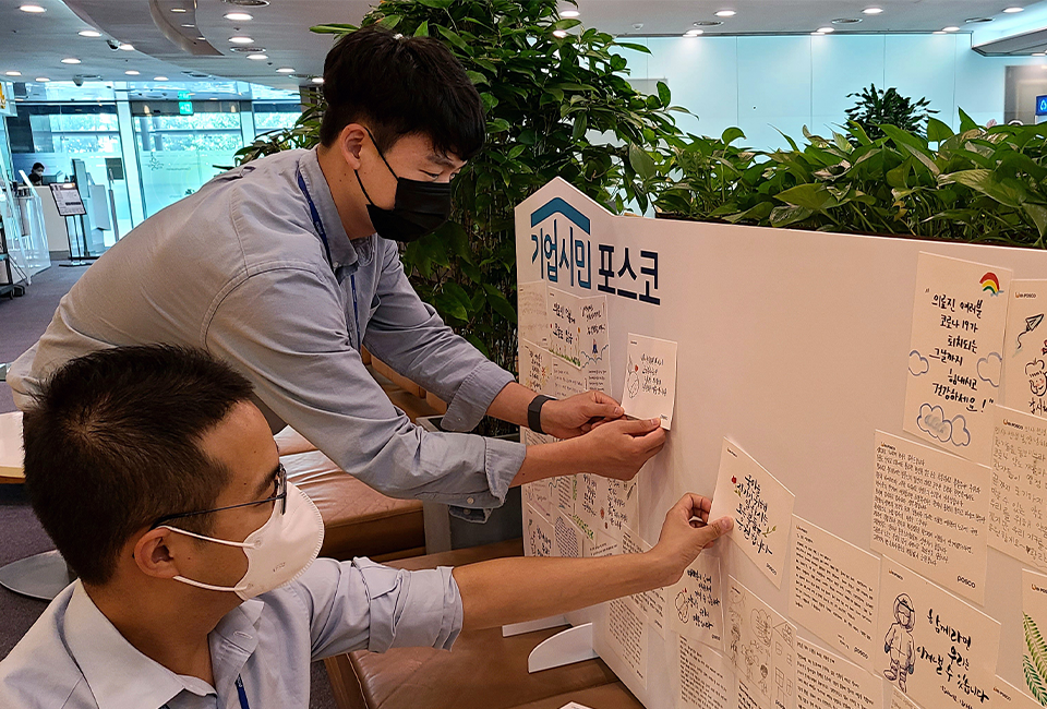 임직원들이 직접 작성한 손편지를 기업시민 포스코 판넬에 붙이는 모습이다.