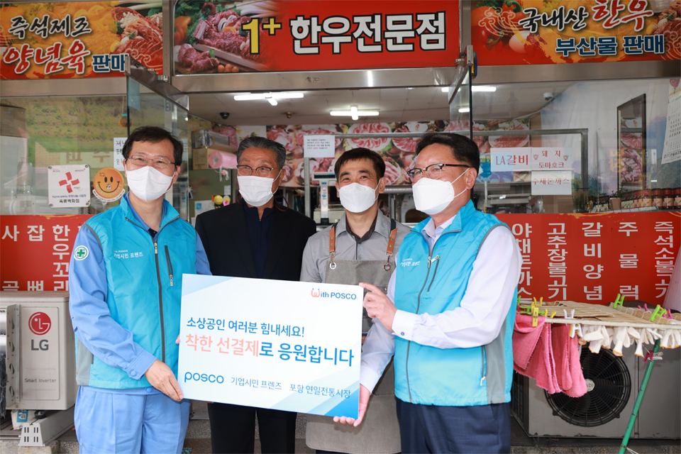 포스코 이주태 구매투자본부장(좌측 끝)과 협력기업인 조선내화 이금옥 대표(우측 끝)가 15일 포항 연일시장을 찾아 착한 선결제 행사를 진행하고 상인들과 기념촬영을 하고 있다.