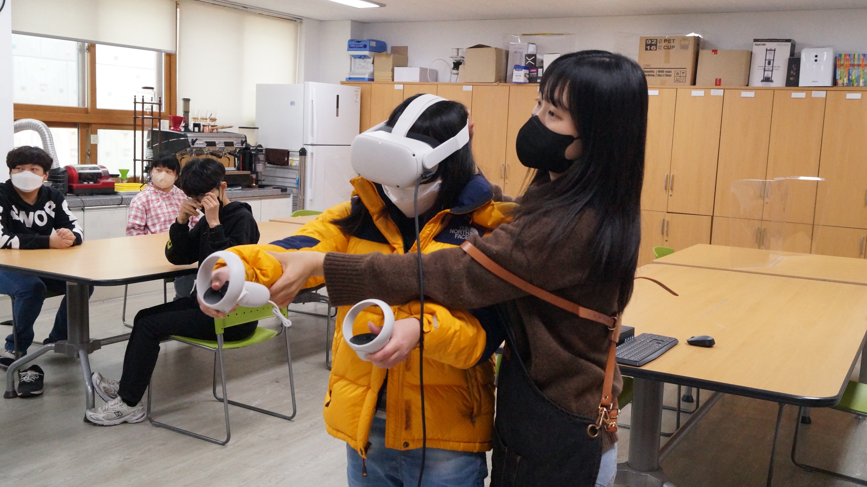 포항 명도학교 여학생이 선생님의 도움을 받아 VR직업훈련을 체험하고 있는 모습이다.