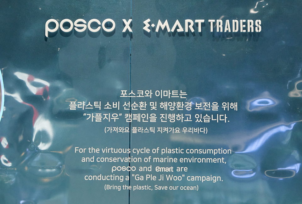 아트월에 쓰여져 있는 문구를 확대한 사진이다. 내용은 다음과 같다. POSCO X EMART TRADERS 포스코와 이마트는 플라스틱 소비 선순환 및 해양환경 보전을 위해 