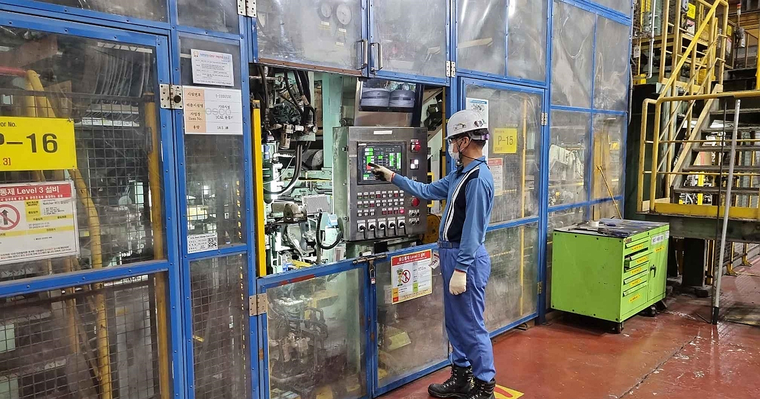 1냉연공장 직원이 포스코 파란색 작업복과 하얀색 작업모를 쓰고 설비 및 안전을 점검하고 있다.