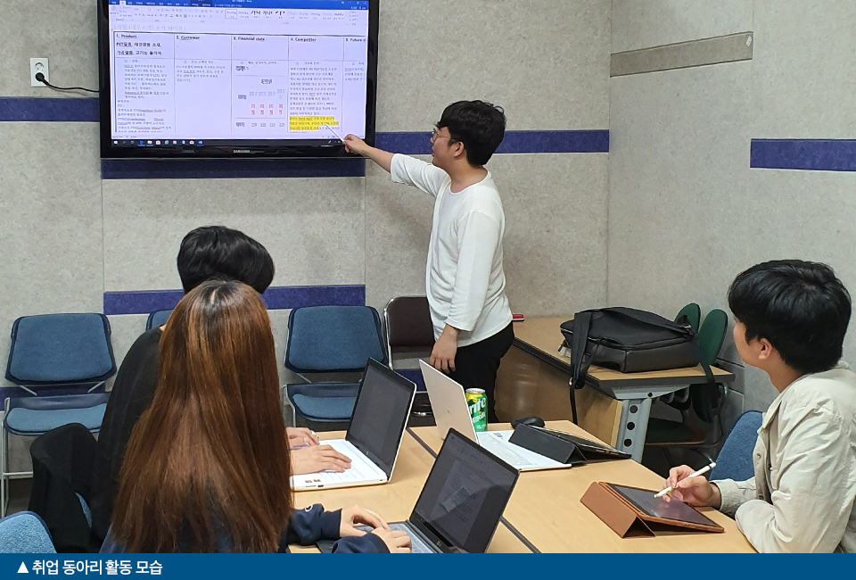 대학시절 취업 동아리 활동 모습의 사진이다. 친구들과 노트북을 가지고 책상에 나란히 앉아있으며 김성욱 사원이 모니터를 가르키며 설명하고있다.