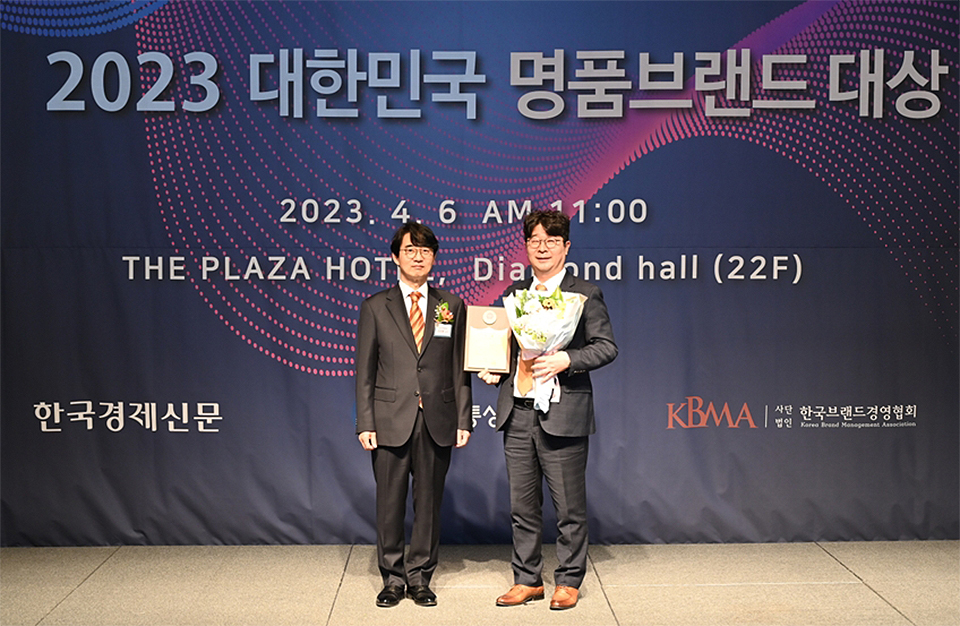 포스코 엄기천 마케팅전략실장(우측)이 4월 6일 서울 중구 더플라자호텔에서 열린 '2023 대한민국 명품브랜드 대상' 시상식에서 김상용 심사위원장(고려대 경영학과 교수)으로부터 친환경 강재 부문 대상을 받은 후 기념촬영하고 있다. 엄기천 실장은 꽃다발과 증서 트로피를 받고 웃고 있다.