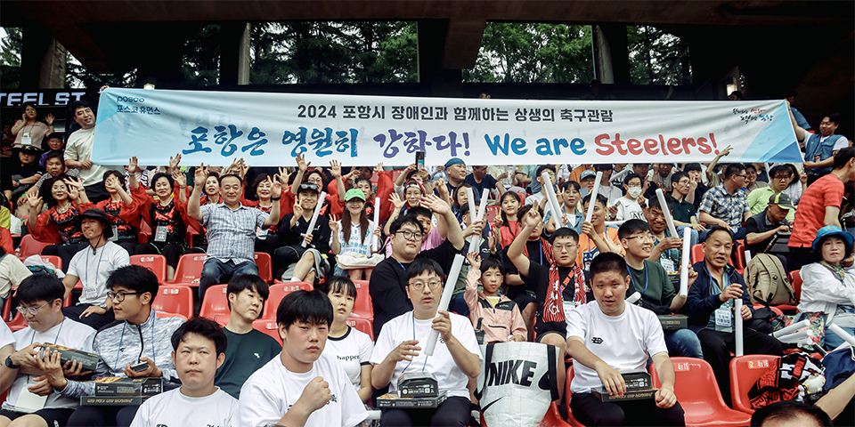 포항시 장애인과 가족들이 경기장에 앉아 축구를 관람하고 있다. 관중 뒤로는 2024포항시 장애인과 함께하는 상생의 축구관람 '포항은 영원히 강하다 We are Steelers! 라고 적힌 대형 현수막이 있다.