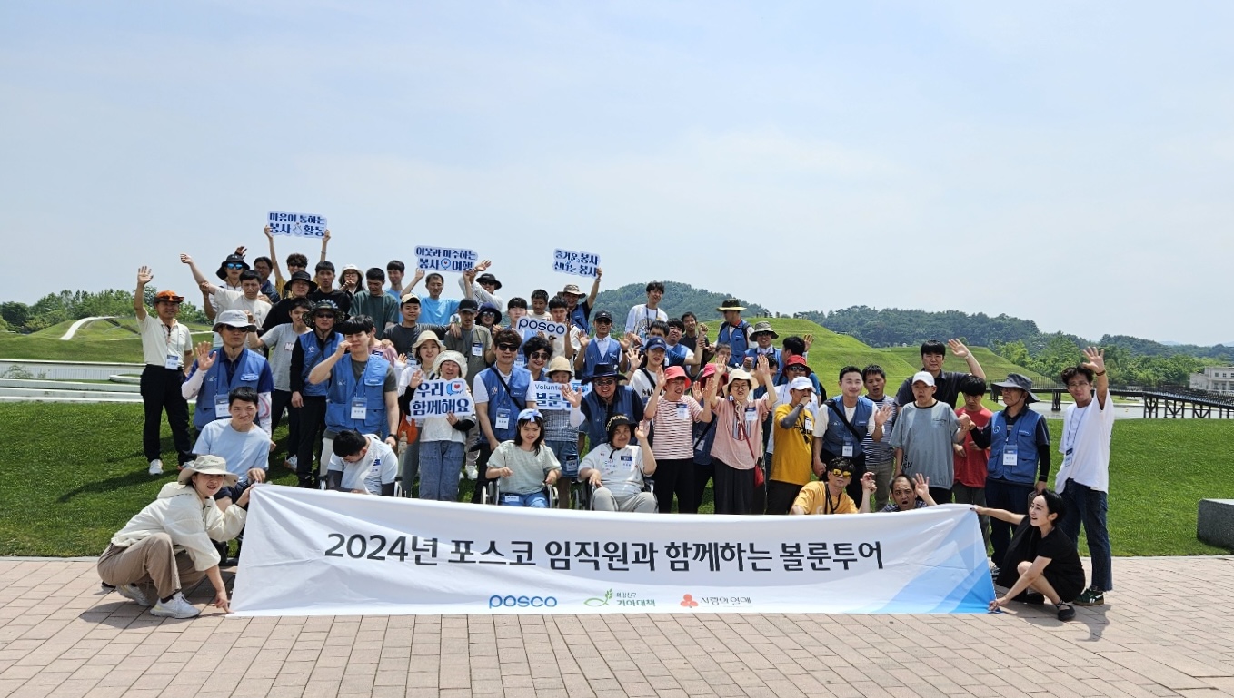 광양 지역 장애인들이 포스코 임직원 및 봉사단과 함께 단체 기념사진을 찍고 있다. 아래 흰 현수막에는 2024년 포스코 임직원과 함꼐하는 볼룬투어 라고 적혀있다.