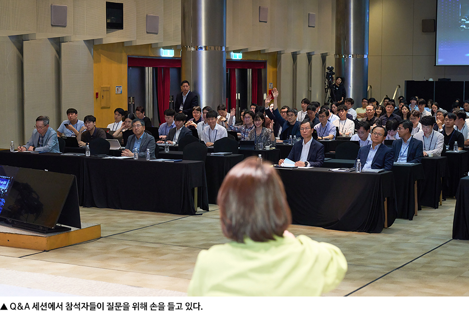 Q&A 세션에서 참석자들이 질문을 위해 손을 들고 있다. 