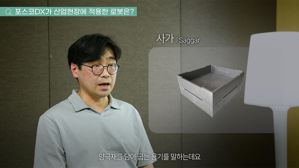 박병조 프로가 포스코DX가 산업현장에 적용한 로봇에 대해 설명하고 있다. 우측에는 사가의 그림이 그려져 있고, 하단에는 양극재를 담아 굽는 용기를 말하는데요. 라고 자막이 적혀 있다. 