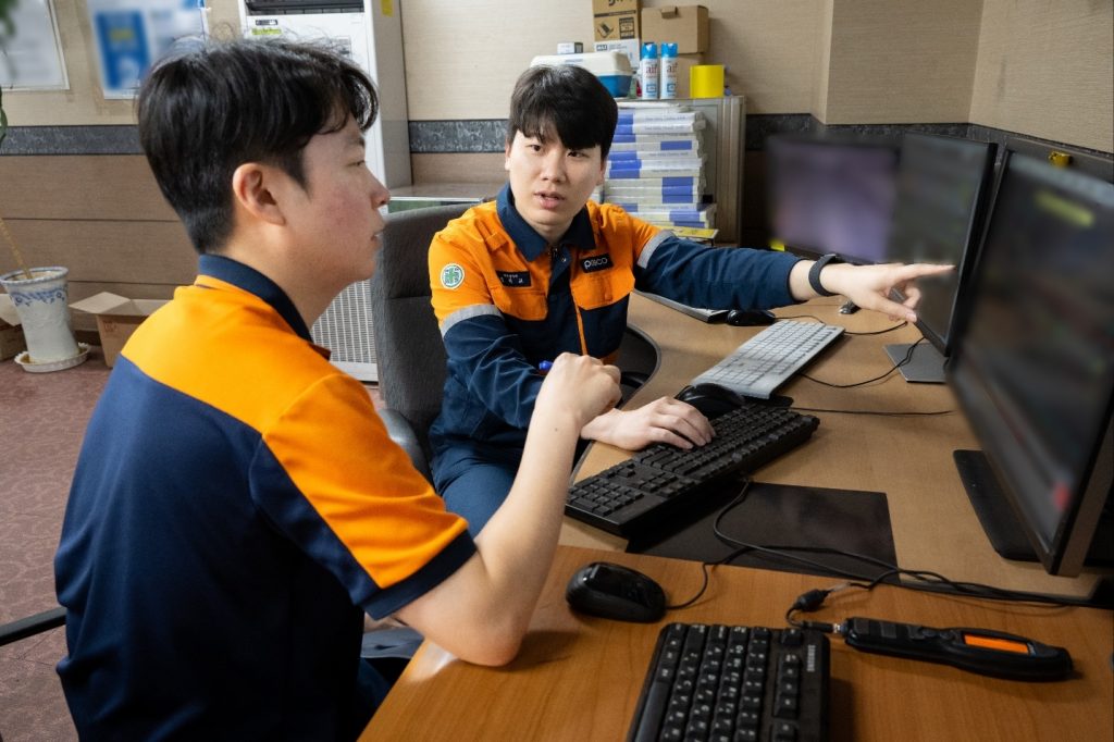 ▲에너지절감 공모전에서 최우수상을 수상한 정현교 대리(뒤)가 직장 동료에게 기술 내용을 설명하고 있는 모습.