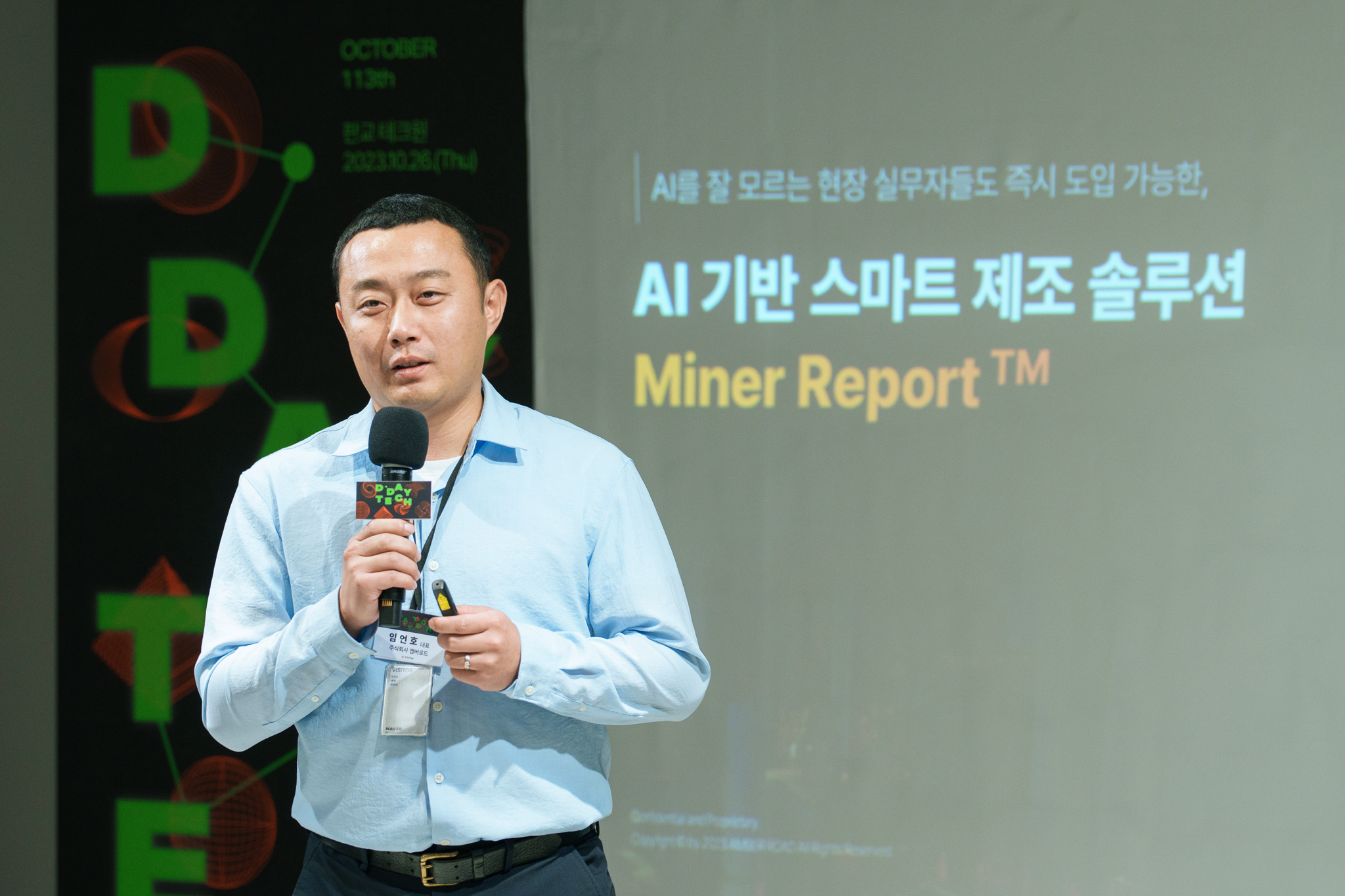 임언호 대표가 AI 기반 스마트 제조 솔루션 마이너리포트에 대해 발표하고 있다. 마이크를 들고 있는 대표 이미지, 스크린에는 AI를 잘 모르는 현장 실무자들도 즉시 도입 가능한, AI 기반 스마트 제조솔루션 Miner Report tm 이라고 쓰여있다. 