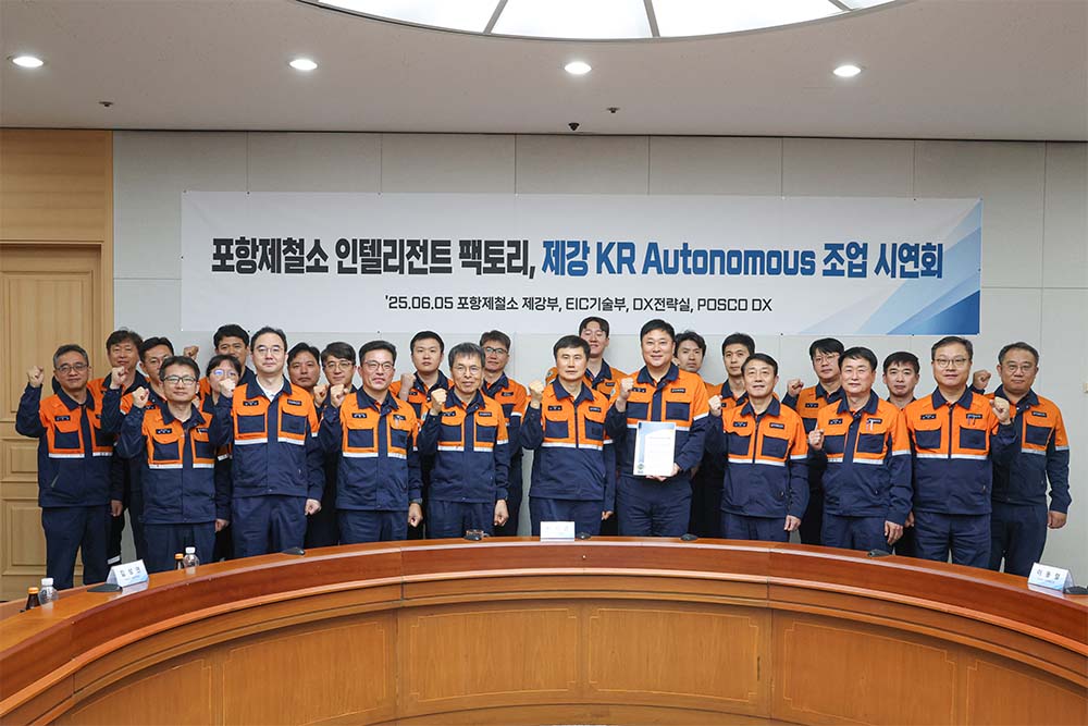 ▲포스코가 6월 5일 포항 3제강공장 'KR 자율조업' 기술 개발을 공식 발표하는 시연회를 개최했다. 관계자들이 단체사진을 찍고 있다. 뒤에 현수막에는 포항제철소 인텔리전트 팩토리, 제강 KR Autonomous 조업 시연회라고 쓰여있다.