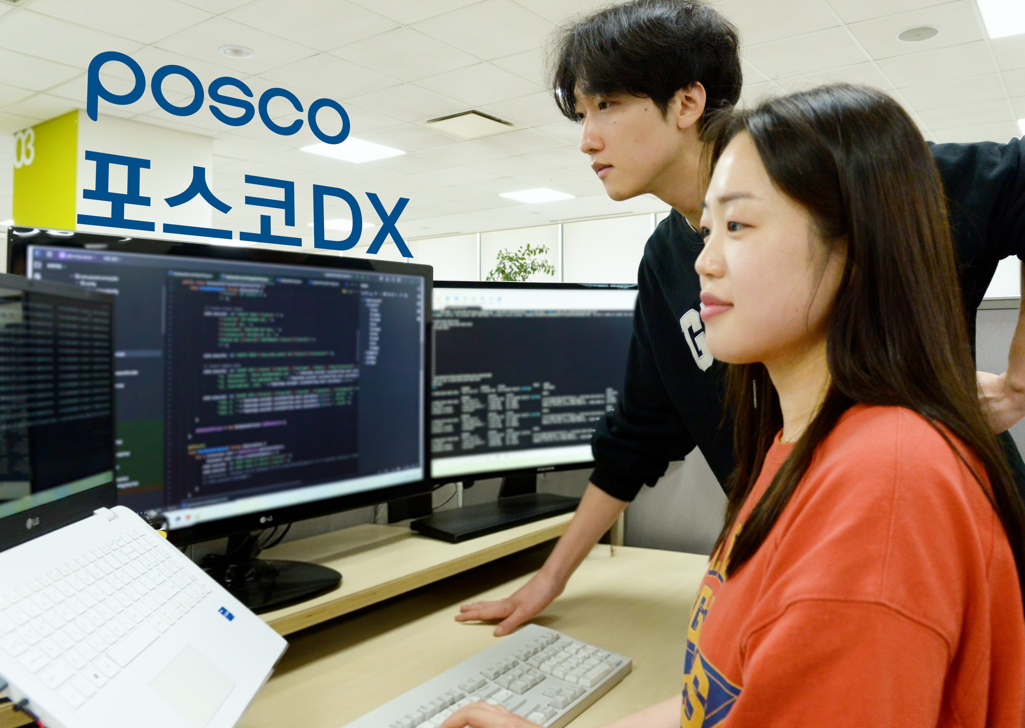 ▲포스코DX의 개발자 직원들이 AI 개발도구를 활용해 개발 업무를 수행하고 있다. 남녀 두명이 컴퓨터 화면을 바라보고 있다.