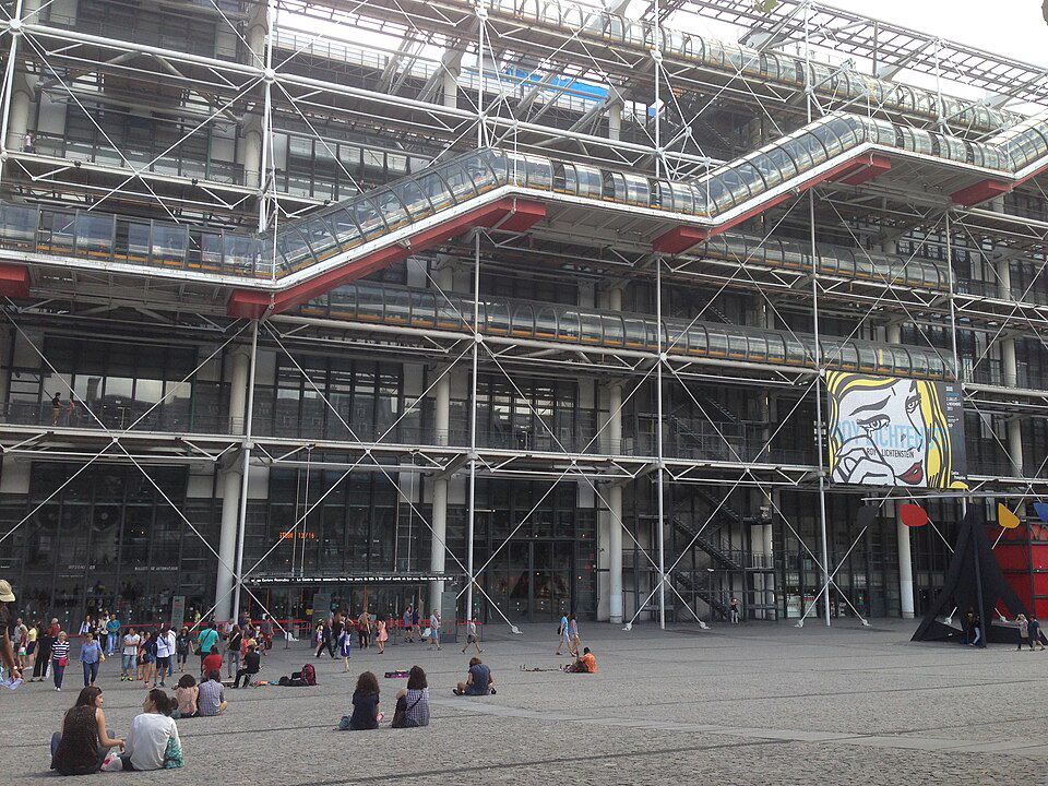 엔디워홀의 '우는 여인' 작품 포스토가 걸린 파리 퐁피두 센터의 전경과 그 앞에 앉아있거나 걸어가는 몇몇 사람들