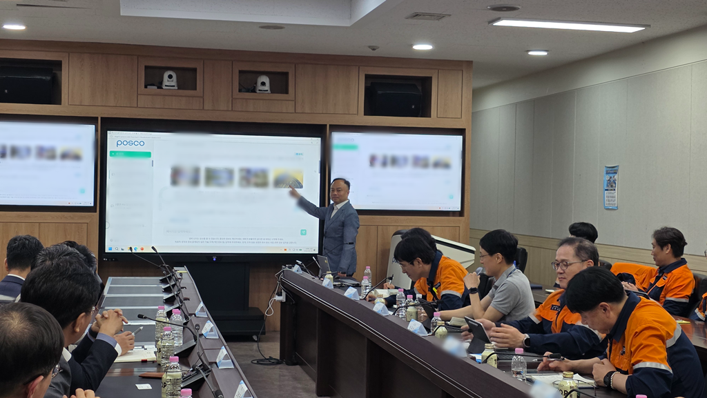 회의실에서 한 남성이 화면 가르키며 설명하고 있는 모습