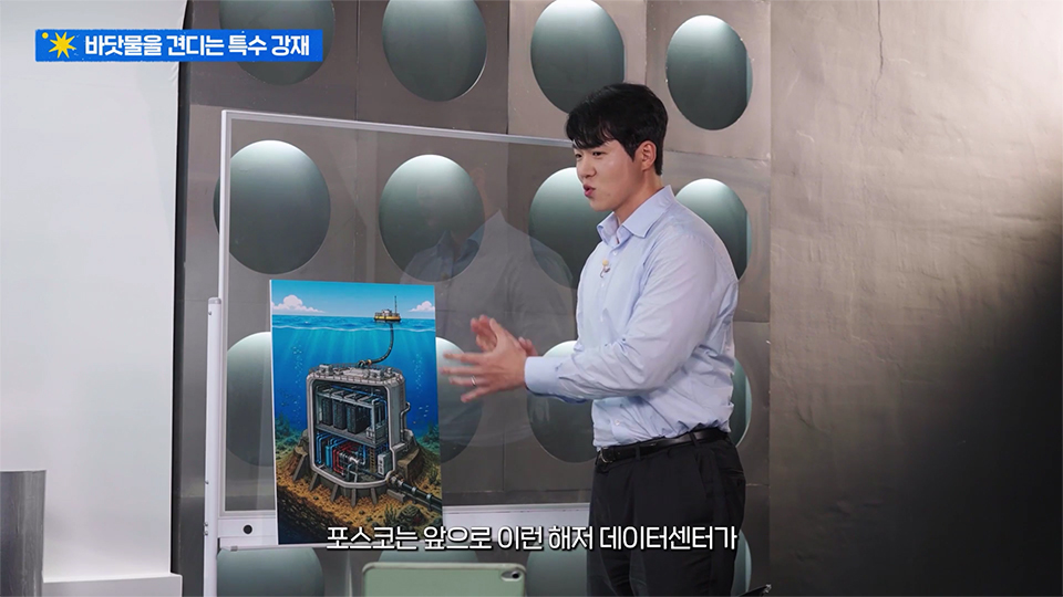 헤저 데이터센터의 이미지를 놓고 이를 설명하는 윤주성 대리 사진 / 상단 제목 : 바닷물을 견디는 특수 강재 / 하단 자막 : 포스코는 앞으로 이런 해저 데이터센터가